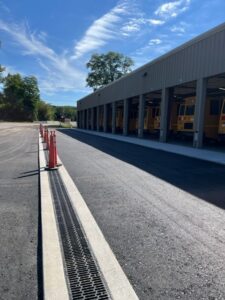 Laid new asphalt around trench drain at the bus garage entrance the week of August 29-September 2, 2022.