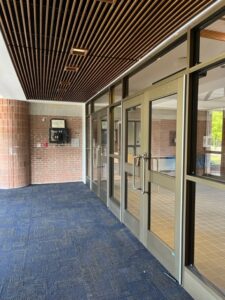 Completed middle school entrance with wooden ceiling, light fixtures, and carpet flooring the week of August 29-September 2, 2022.