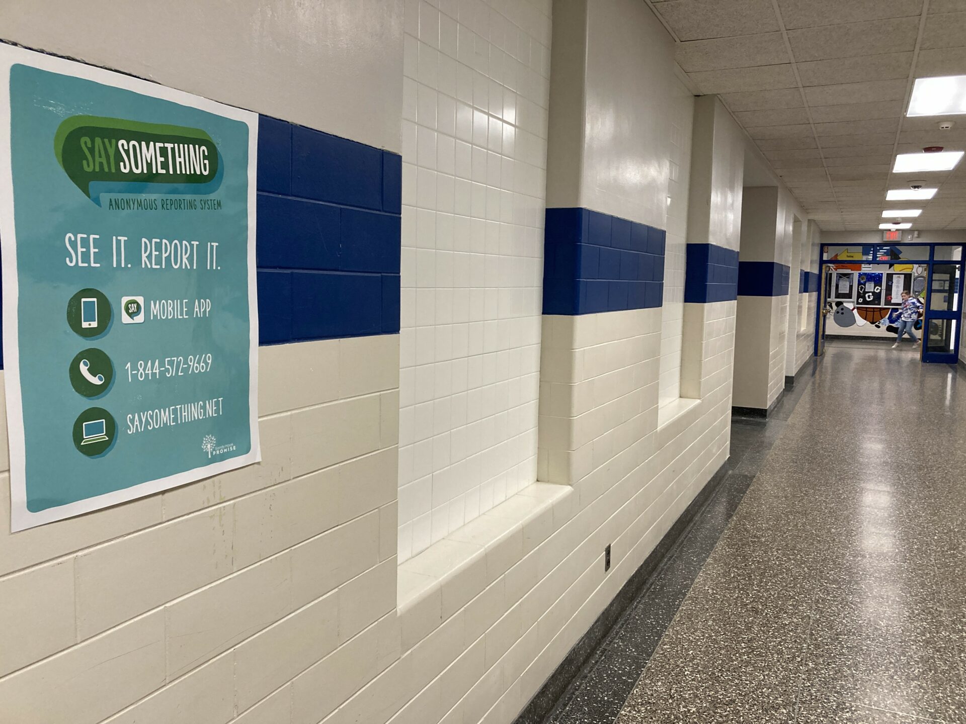 A Say Something Anonymous Reporting System poster hung prominently in a main hallway at Gowanda High School. 